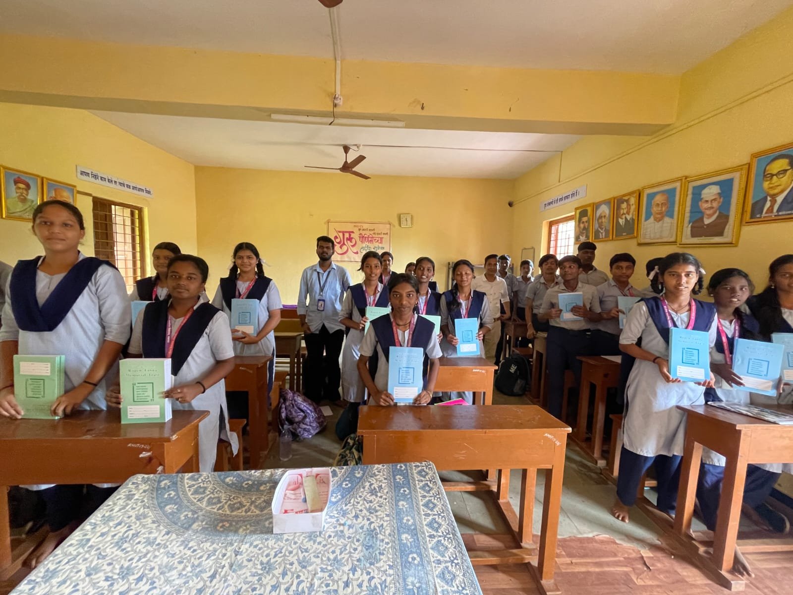 Students standing in classroom with their new books and notebooks